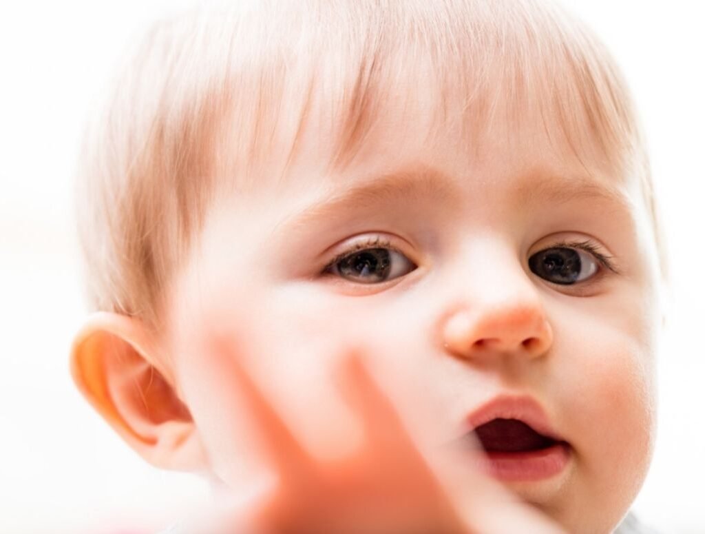 Closeup image of a child reaching out to you with blurred fingers