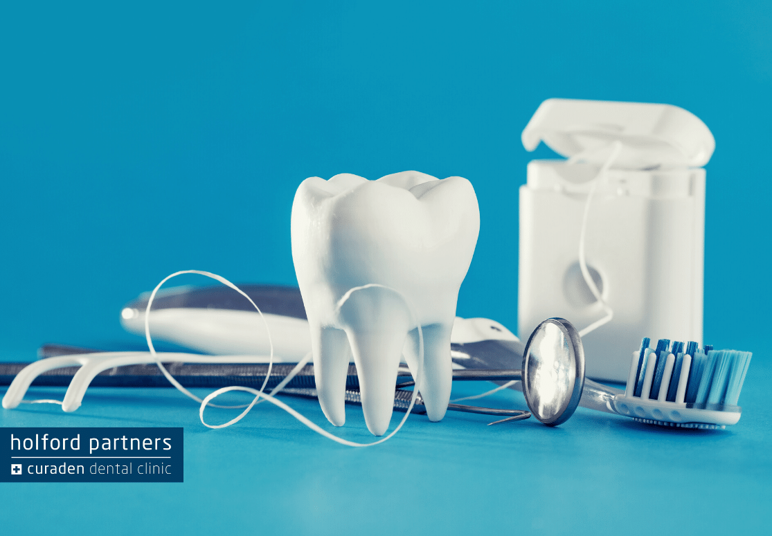Image of dental tools and a tooth sculpture or model with a blue background