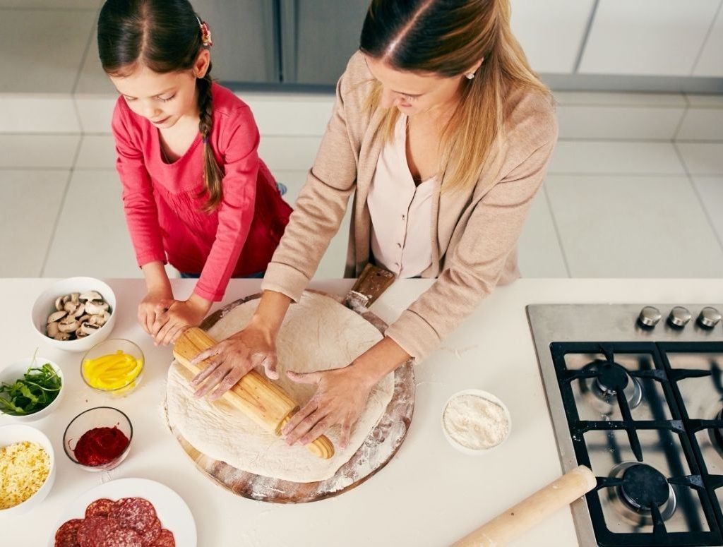 Image of a lady teaching a young girl how to cook healthy food