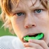 Image of a boy in sportswear wearing an athletic mouthguard