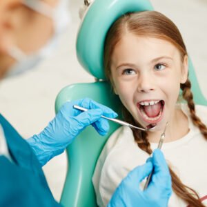 image of a girl happily getting a dental checkup from a dentist